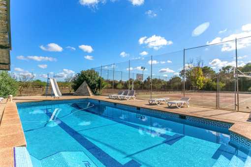 Fantastic pool area with sunloungers next to the tennis court